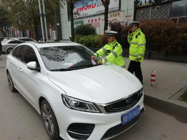 交警对违停车辆张贴罚单 陈宇 摄